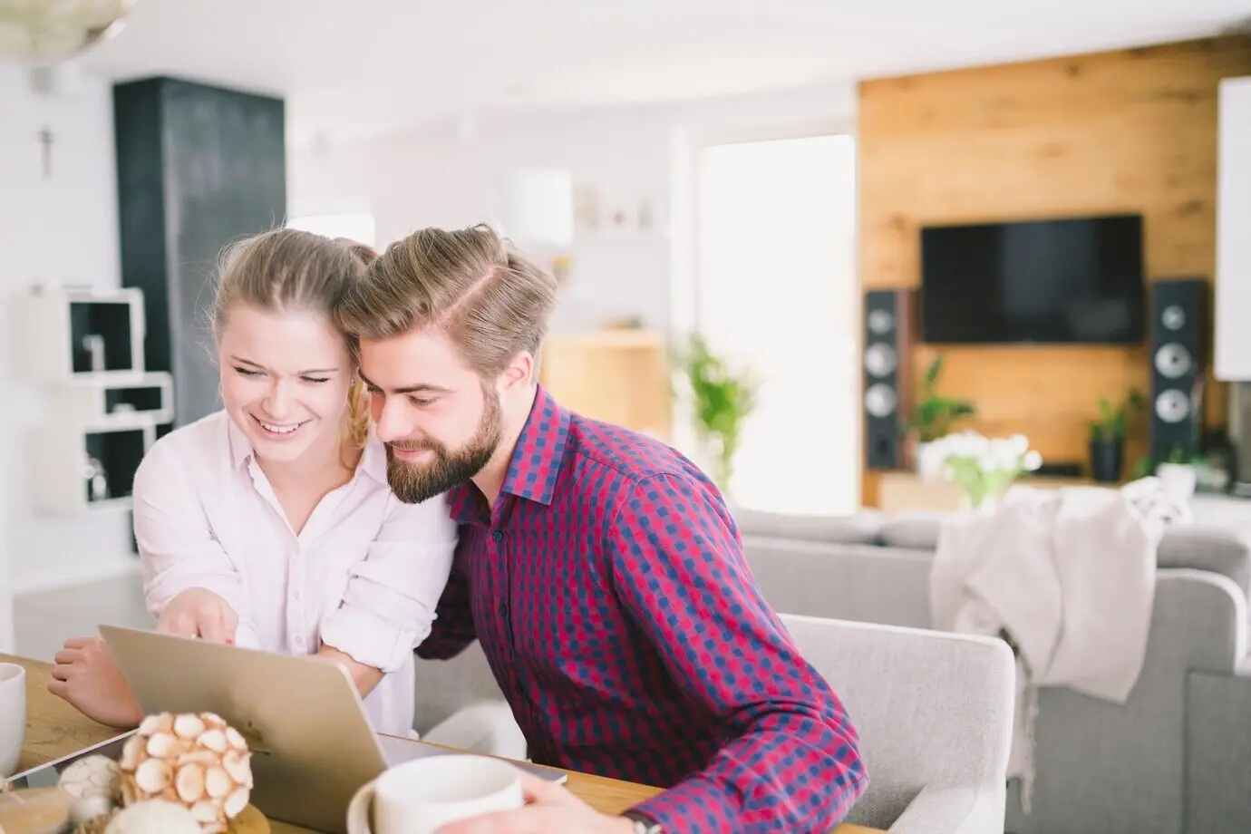 Ein fröhliches junges Paar benutzt einen Laptop.